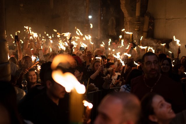 Christian Orthodox pilgrims hold candles during the Holy Fire ceremony at the Church of the Holy Sepulchre, where many Christians believe Jesus was crucified, buried and rose from the dead, in the Old City of Jerusalem. Saturday, May 4, 2024. In the annual ceremony that has been observed for over a millennium, a flame taken from Jesus' tomb is used to light the candles of fervent believers of Christian Orthodox communities near and far. The devout believe the origin of the flame is a miracle and is shrouded in mystery. (Photo by Leo Correa/AP Photo)