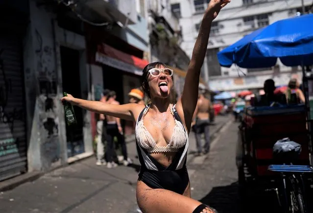 A reveler strikes a pose during an unofficial carnival block party referred to as “blocos”, in Rio de Janeiro, Brazil, Saturday, February 26, 2022. (Photo by Silvia Izquierdo/AP Photo)