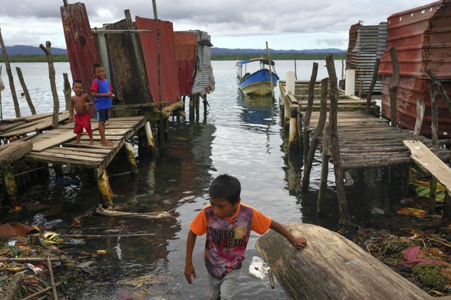 Boys stand on piers and walkways on Gardi Sugdub Island, part of the San Blas archipelago off Panama's Caribbean coast, Saturday, May 25, 2024. Due to rising sea levels, about 300 Guna Indigenous families will relocate to new homes, built by the government, on the mainland. (Photo by Matias Delacroix/AP Photo)