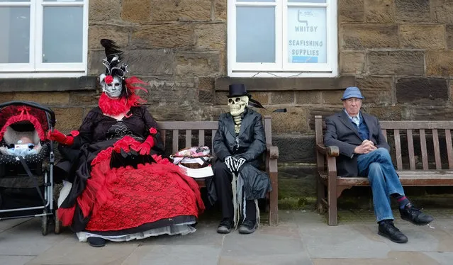 Two goth women sit on a bench during the Goth weekend on April 26, 2014 in Whitby, England. The Whitby Goth weekend began in 1994 and happens twice each year. Thousands of extravagantly dressed people who follow Steampunk, Cybergoth, Romanticism or Victoriana visit the town to take part in the celebration of Goth culture. (Photo by Ian Forsyth/Getty Images)