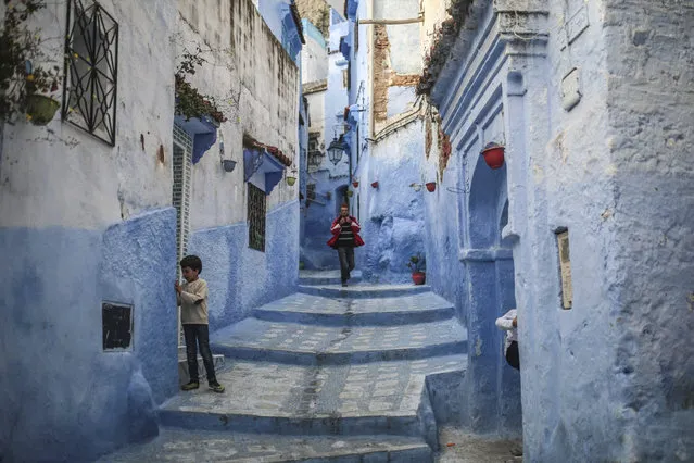 A boy plays outside his house while a man walks down an alleyway in the Medina of Chefchaouen, a picturesque town well-known for its blue painted houses and alleyways, in northern Morocco, Saturday, April 29, 2017. (Photo by Mosa'ab Elshamy/AP Photo)