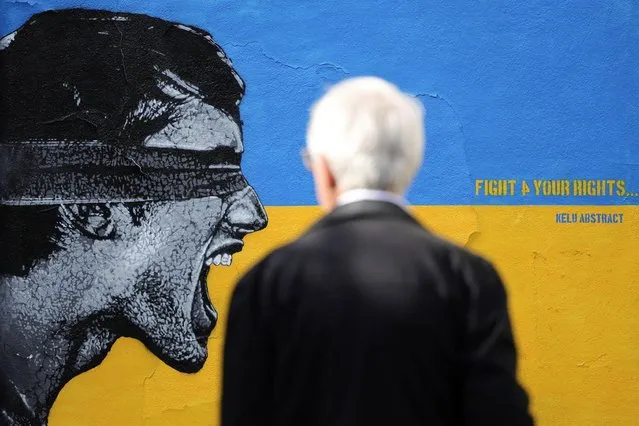 A man looks at a mural in support of Ukraine by French street artist Kelu Abstract following Russia's invasion of Ukraine, in Paris, France, March 14, 2022. (Photo by Sarah Meyssonnier/Reuters)