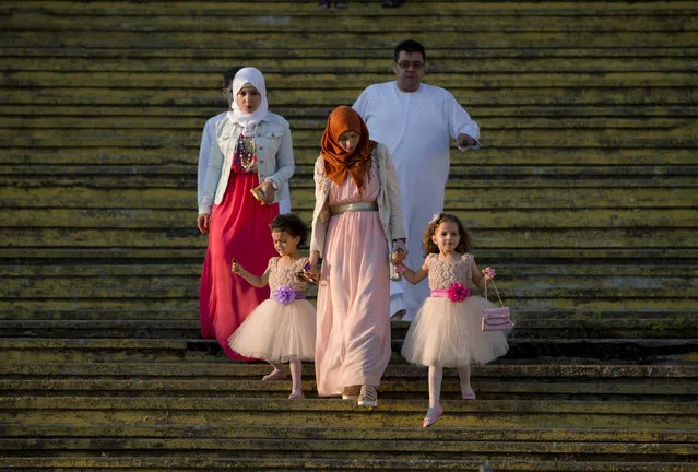 A Muslim family arrives for the Eid al-Fitr prayers in Bucharest, Romania, Friday, July 17, 2015. Members of the Romania Muslim community joined prayers at the Dinamo stadium in the Romanian capital, in the largest Muslim public gathering of the year. Eid al-Fitr marks the end of the holy fasting month of Ramadan. (Photo by Vadim Ghirda/AP Photo)