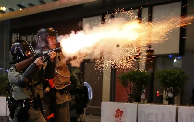 A riot police officer fires a tear gas canister toward anti-government demonstrators during a protest in Hong Kong's tourism district of Tsim Sha Tsui, China on October 27, 2019. (Photo by Ammar Awad/Reuters)