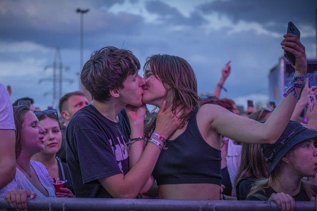 People enjoy a concert at the Atlas Festival in Kyiv, Ukraine, Sunday, July 21, 2024. This year, Ukraine's largest music festival struck a different chord. Gone were the international headliners, the massive performance halls and the hundreds of thousands of visitors. (Photo by Anton Shtuka/AP Photo)