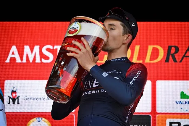 Poland's Michał Kwiatkowski drinks beer as he celebrates his victory on the podium of the 56th Amstel Gold Race 2022 on April 10, 2022 in Valkenburg. (Photo by Eric Lalmand/ANP via AFP Photo)