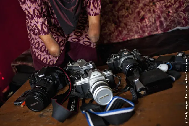 Armless professional photographer Rusidah, 44, carries out camera maintenance