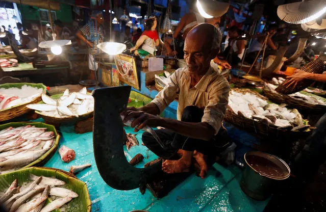 A vendor cuts fish for a customer at a wholesale fish market in Kolkata, India, April 12, 2017. (Photo by Rupak De Chowdhuri/Reuters)