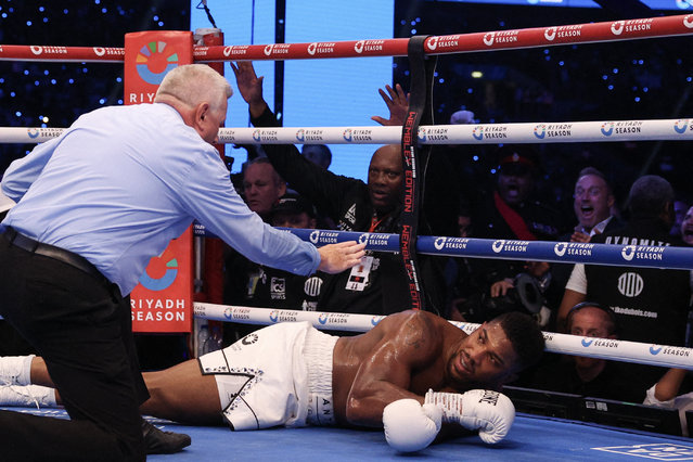 Britain's Anthony Joshua is knocked to the ground by Britain's Daniel Dubois during their heavyweight boxing match for the IBF world title at Wembley Stadium in London on September 21, 2024. (Photo by Adrian Dennis/AFP Photo)