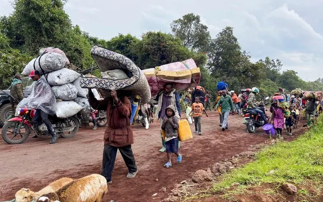 Congolese civilians carry their belongings as they flee near the Congolese border with Rwanda after fightings broke out in Kibumba, outside Goma in the North Kivu province of the Democratic Republic of Congo on May 24, 2022. (Photo by Djaffar Sabiti/Reuters)