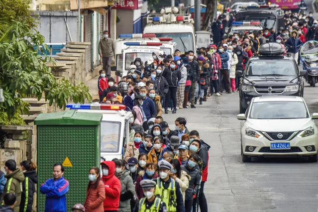 People line up to buy face masks from a medical supply company in Nanning in southern China's Guangxi Zhuang Autonomous Region, Wednesday, January 29, 2020. Countries began evacuating their citizens Wednesday from the Chinese city hardest-hit by a new virus that has now infected more people in China than were sickened in the country by SARS. (Photo by Chinatopix via AP Photo)