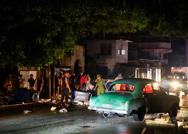 Cuban police and military stand next to debris used to block a street during a protest against a blackout, after opening the street up to traffic, in Havana, Cuba, on October 19, 2024. (Photo by Norlys Perez/Reuters)