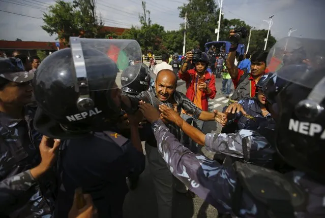 Nepalese police detain a protester during a general strike organised by a 30-party alliance led by a hardline faction of former Maoist rebels, who are protesting against the draft of the new constitution, in Kathmandu, Nepal August 16, 2015. (Photo by Navesh Chitrakar/Reuters)