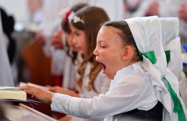 A child dressed in the traditional clothes of the Sorbs attends a holy mass during the annual Corpus Christi celebration in Ralbitz, Germany, June 16, 2022. (Photo by Matthias Rietschel/Reuters)