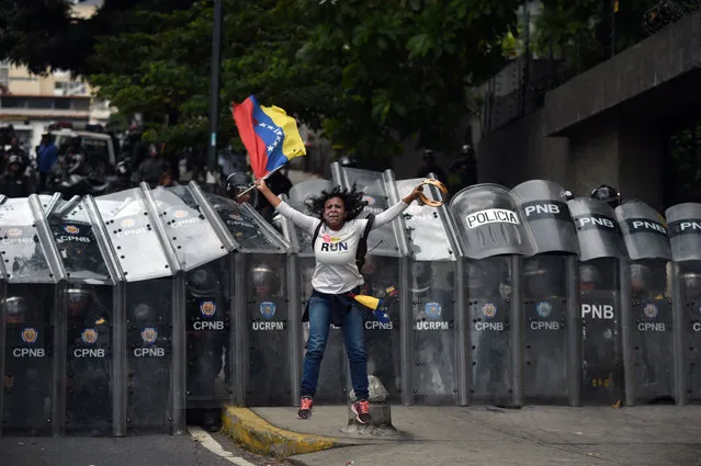 A supporter of Venezuelan opposition leader Juan Guaido reacts in fron of Venezuelan security forces preventing them to continue their way to the National Assembly in Caracas on March 10, 2020. (Photo by Federico Parra/AFP Photo)