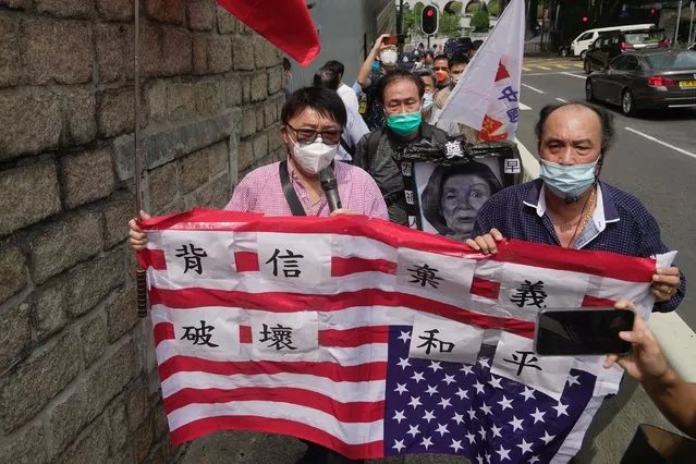 Pro-China supporters hold U.S. flag and a picture of U.S. House Speaker Nancy Pelosi during a protest outside the Consulate General of the United States in Hong Kong, Wednesday, August 3, 2022. U.S. House Speaker Nancy Pelosi arrived in Taiwan late Tuesday, becoming the highest-ranking American official in 25 years to visit the self-ruled island claimed by China, which quickly announced that it would conduct military maneuvers in retaliation for her presence. (Photo by Kin Cheung/AP Photo)