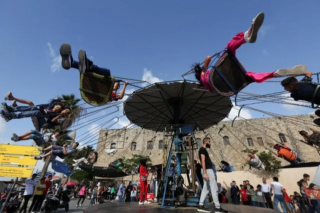 Children enjoy a swing ride during the Muslim holiday of Eid al-Adha in Sidon, Lebanon on July 10, 2022. (Photo by Aziz Taher/Reuters)