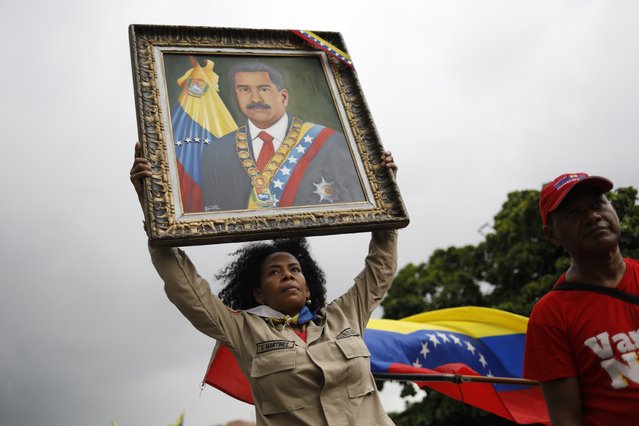A member of the Bolivarian Militia holds up a painting depicting President Nicolas Maduro during a rally celebrating Maduro's July 28 reelection, in Caracas, Venezuela, Saturday, September 28, 2024. (Photo by Cristian Hernandez/AP Photo)