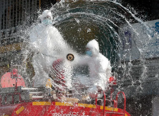 Firefighters spray disinfectant at a market to curb the spread of coronavirus in Yangon, Myanmar, 20 April 2020. Countries around the world are taking increased measures to stem the widespread of the SARS-CoV-2 coronavirus which causes the Covid-19 disease. (Photo by Nyein Chan Naing/EPA/EFE)