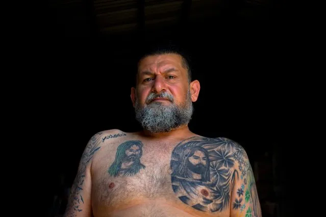 In this Tuesday, May 31, 2016 photo, Ali Hussein Nasreddine, 50, poses for a photo showing his tattoo of Shiite Muslims' first Imam Ali, and his son Imam Hussein, the grandson of the Prophet Muhammed in the southern suburb of Beirut, Lebanon. (Photo by Hassan Ammar/AP Photo)