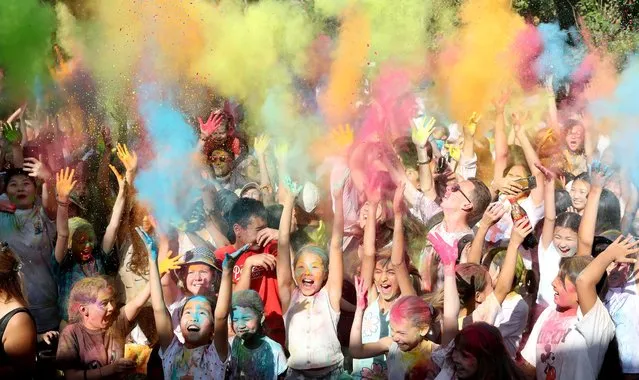 Young people take part in the Festival of Colors at Asanbai Park in Bishkek, Kyrgyzstan, 04 September 2022. The event refers to the traditional Holi festival in northern India. The festival is based on the patriotic idea of uniting young people, freedom of expression and a bright holiday, the main tradition of which is to sprinkle each other with colorful paints. Therefore, ColorFest is also called the Festival of Colors. (Photo by Igor Kovalenko/EPA/EFE)
