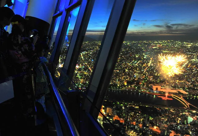 Visitors watch fireworks from Tokyo Skytree's observation deck on Saturday, July 30, 2016 in Tokyo's Sumida Ward. The nighttime display, which kicked off around 7:00 p.m., was part of the Sumida River Fireworks Festival, one of the biggest fireworks galas in Tokyo. Tokyo Skytree is located right in front of the river and has hosted the viewing event since 2012, which has grown very popular. (Photo by Yoshiaki Miura)