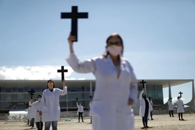 Nurses wearing protective face masks hold crosses during a symbolic protest and tribute for health workers on Labour Day, amid the spread of the coronavirus disease (COVID-19), in Brasilia, Brazil, May 1, 2020. (Photo by Ueslei Marcelino/Reuters)