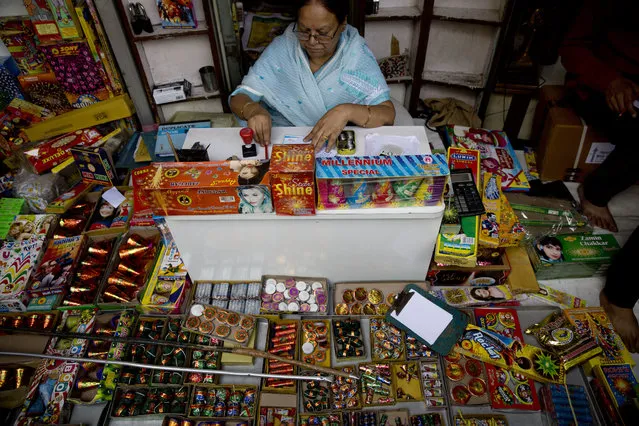 An Indian shopkeeper sells fire crackers in New Delhi, India, Monday, October 9, 2017. India's Supreme Court has banned the sale of fireworks in New Delhi and nearby towns, 10 days before the Hindu festival of Diwali, in a move to curb the capital's deadly air pollution. (Photo by Tsering Topgyal/AP Photo)
