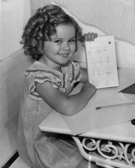 7-year-old U.S. american child movie star Shirley Temple smiles as she proudly presents the golden star she received from her teacher for an exercise she did perfectly at her first day at school September 10, 1935 in Hollywood, Ca., USA. (Photo by AP Photo)