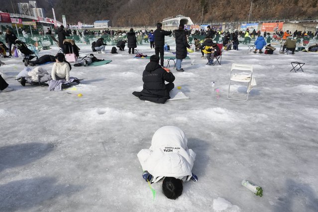 A boy casts a line through a hole drilled in the surface of a frozen river during a trout catching contest in Hwacheon, South Korea, Sunday, February 2, 2025. (Photo by Ahn Young-joon/AP Photo)