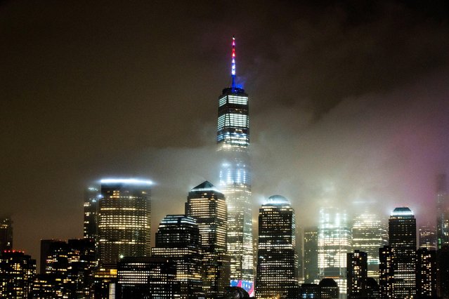 The One World Trade Center is illuminated in red, white and blue in recognition of the ongoing nationwide effort to combat coronavirus during the outbreak of the coronavirus disease (COVID-19) in New York City, as it is seen from Exchange Place, New Jersey, March 30, 2020. (Photo by Eduardo Munoz/Reuters)