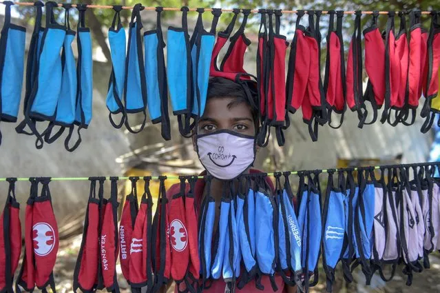 A street vendor poses as he arranges facemasks to sell on the roadside as a preventive measure against the spread of the COVID-19 coronavirus on the outskirts of Hyderabad on June 5, 2020. (Photo by Noah Seelam/AFP Photo)