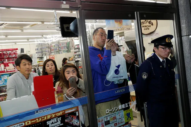 Police officers hold people inside shops as President Trump, Japan's Prime Minister Shinzo Abe and their wives eat dinner nearby at Ginza Ukai Tei in Tokyo, Japan on November 5, 2017. (Photo by Jonathan Ernst/Reuters)