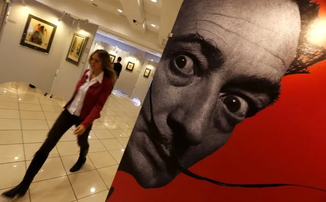 A visitor walks past a portrait of Salvador Dali during the exhibition “Cryptography” in St. Petersburg October 5, 2014. The exhibition features 61 original colour graphic works of Salvador Dali which were collected from private collections and galleries in Europe and America, organizers said. (Photo by Alexander Demianchuk/Reuters)