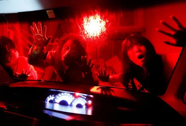 Actors dressed as zombies and ghouls perform during a drive-in haunted house show by Kowagarasetai (Scare Squad), for people inside a car in order to maintain social distancing amid the spread of coronavirus, at a garage in Tokyo, Japan on July 3, 2020. (Photo by Issei Kato/Reuters)
