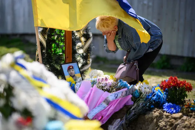 Angela Bondar grieves at the grave of her son, fallen soldier Vladimir Bondar, on May 01, 2022 in Lviv, Ukraine. Living in an occupied territory of the Kherson region, Angela Bondar was unable to attend the funeral of her son, who died on March 31. The practice of visiting relatives' graves the week after orthodox Easter, a tradition referred to as Hrobki or Provody, held added poignancy as the country mourns the civilians and soldiers lost to the war with Russia. (Photo by Leon Neal/Getty Images)