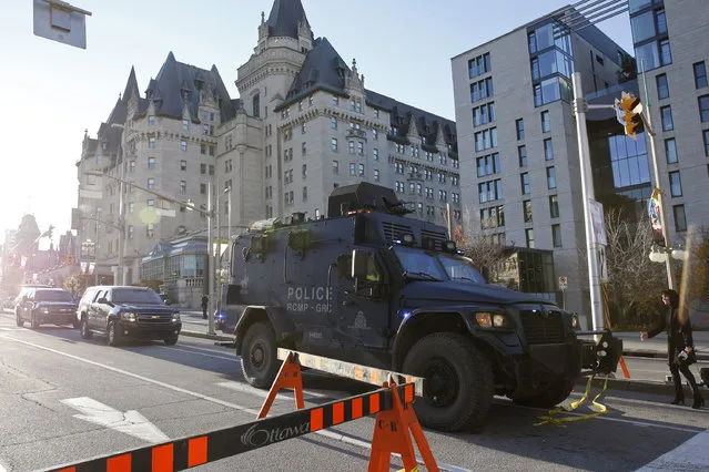 A Royal Canadian Mounted Police vehicle passes the Fairmont Chateau Laurier as it leaves a secure area downtown following shootings in Ottawa October 22, 2014. (Photo by Blair Gable/Reuters)