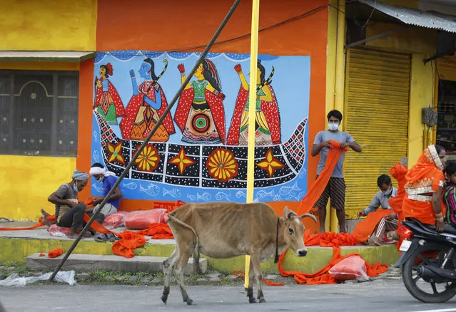 Workers decorate one of the main street as part of preparations for the groundbreaking ceremony of a temple to the Hindu god Ram in Ayodhya, in the Indian state of Uttar Pradesh, Monday, August 3, 2020. (Photo by Rajesh Kumar Singh/AP Photo)