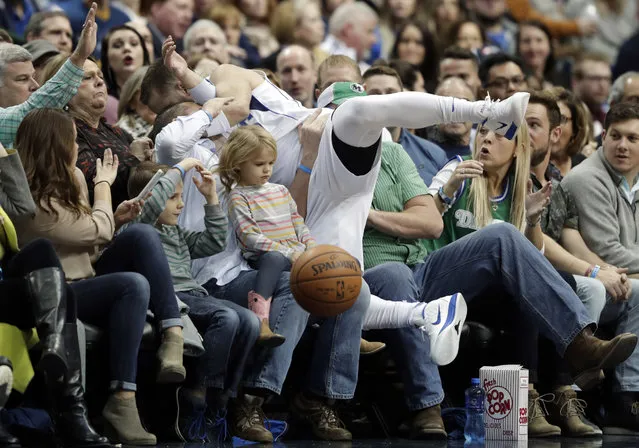 Fans brace as Dallas Mavericks' J.J. Barea (5) of Puerto Rico lands in the front two rows chasing a loose ball in the first half of an NBA basketball game against the Orlando Magic on Tuesday, January 9, 2018, in Dallas. (Photo by Tony Gutierrez/AP Photo)