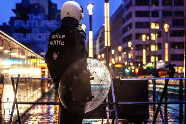 A police officer holds a shield while securing the Law Street in the European Quarter around the EU Commission Berlaymont building, in Brussels, Belgium, 26 February 2024. European farmers will gather on 26 February to demonstrate on the sidelines of a meeting of EU agriculture and fisheries ministers in Brussels. (Photo by Olivier Matthys/EPA)