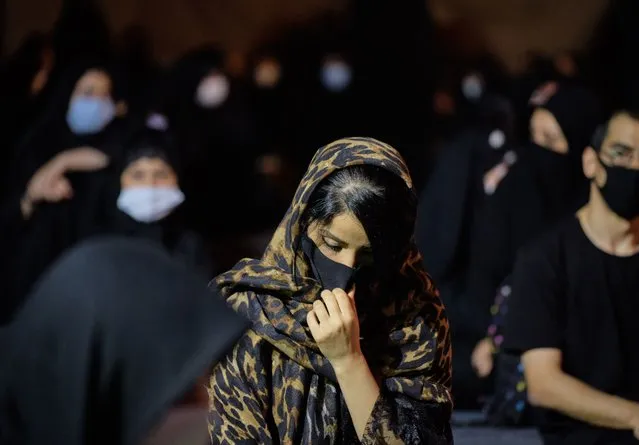 An Iranian Shiite Muslim wearing a protective face mask attends a Muharram mourning ceremony in southern Tehran on August 28, 2020. The new coronavirus (COVID-19) put the country in the red situation, and the health officials warned people for observing social distancing and health protocols in the Muharram mourning ceremonies and being ready for the third wave of the COVID-19 disease that will begin in the fall. (Photo by Morteza Nikoubazl/NurPhoto via Getty Images)