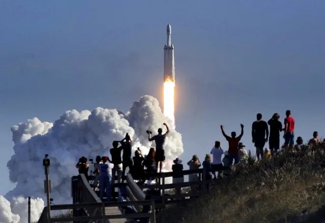 The crowd cheers at Playalinda Beach in the Canaveral National Seashore, just north of the Kennedy Space Center, during the successful launch of the SpaceX Falcon Heavy rocket, Tuesday, February 6, 2018. Playalinda is one of closest public viewing spots to see the launch, about 3 miles from the SpaceX launchpad 39A. (Photo by Joe Burbank/Orlando Sentinel via AP Photo)