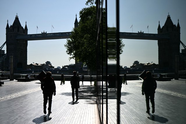 Commuters make their way to work in the morning sunshine backdropped by Tower Bridge in London on July 3, 2025. (Photo by Justin Tallis/AFP Photo)