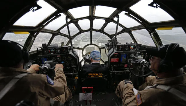 World War II veteran David Oreck, 92, center, sits in the bombardier seat of the B-29 Superfortress bomber "Fifi," during a flight over New Orleans, Thursday, October 22, 2015. Oreck flew missions in a B-29 during the war. The plane, part of the Commemorative Air Force, is in town for the WWII AirPower Expo 2015, hosted by the National World War II Museum, which runs through the weekend. (Photo by Gerald Herbert/AP Photo)