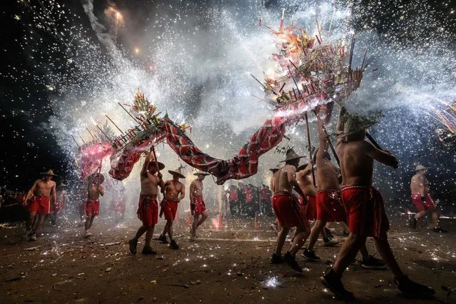 Folk artists perform fire dragon dance amid sparkles on February 1, 2023 in Jieyang, China. With the release of epidemic control, the suspended Fire Dragon Dance was resumed, and a large number of citizens came to participate. (Photo by John Ricky/Anadolu Agency via Getty Images)