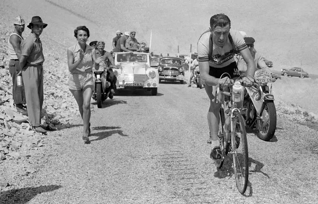 Frenchman Louison Bobet, cheered on by his wife, Christiane, climbs the Mont Ventoux on his way to winning the 11th stage of the Tour de France between Marseille and Avignon, 18 July 1955. Bobet went on to win his third consecutive Tour de France. (Photo by STF/AFP Photo)