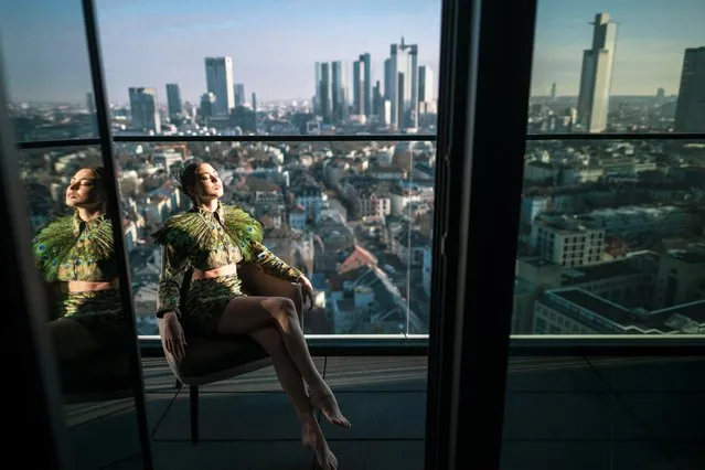 Model Marie-Claire wears a two-piece consisting of jacket and mini skirt made of a velvet fabric with peacock print of Designer Samuel Gärtner new collection during a shooting prior to Frankfurt Fashion Week on January 10, 2022 in Frankfurt am Main, Germany. She posed on a stool on a balcony on the 22nd floor of the Melia Frankfurt City in front of the Frankfurt skyline. Frankfurt Fashion Week will run from 17 to 21 January 2022 as a hybrid event with both physical and digital events. But it is not clear whether physical events can take place at all. (Photo by Thomas Lohnes/Getty Images)