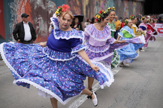 Teachers dance as they march to Congress to protest against the Statutory Law on Education, a government initiative for education reforms being considered by lawmakers, on the first day of a teachers' strike in Bogota, Colombia, Wednesday, June 12, 2024. (Photo by Fernando Vergara/AP Photo)