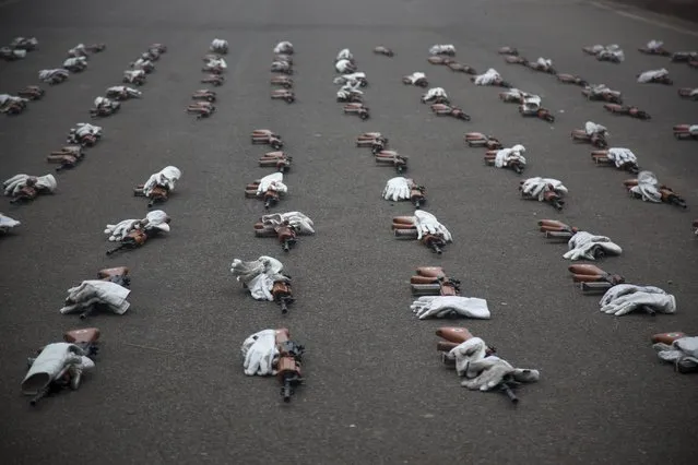 Guns and gloves of India's Air Force soldiers lie on a road during rehearsals for the upcoming Republic Day parade in New Delhi, India, Tuesday, December 23, 2014. India marks Republic Day on January 26 with military parades across the country. (Photo by Tsering Topgyal/AP Photo)
