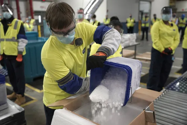 Dry ice is poured into a box containing the Pfizer-BioNTech COVID-19 vaccine as it is prepared to be shipped at the Pfizer Global Supply Kalamazoo manufacturing plant in Portage, Mich., Sunday, December 13, 2020. (Photo by Morry Gash/AP Photo/Pool)